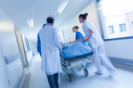 病人在担架或担架到急救室的医生与护士在医院走廊通过速度推上运动模糊的照片