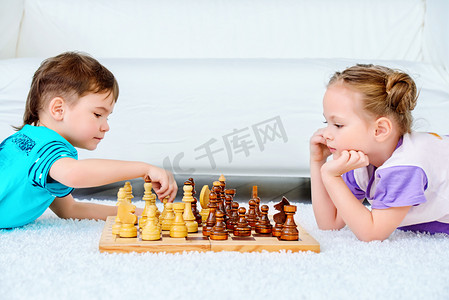 竞争。孩子们在家里下棋. 