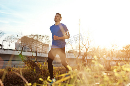 小男生演讲摄影照片_英俊的男运动员，在日落时分 （小明珠在公园跑步