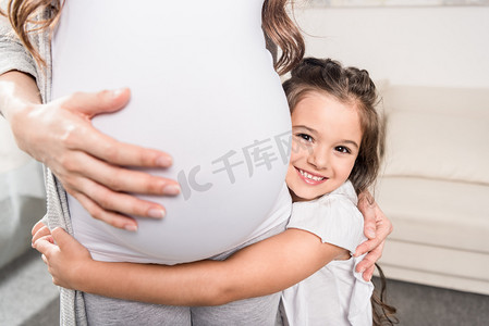 女孩拥抱怀孕妈妈