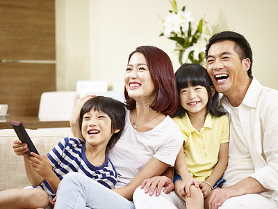 亚洲家庭摄影照片_亚洲家庭有两个孩子在家看电视