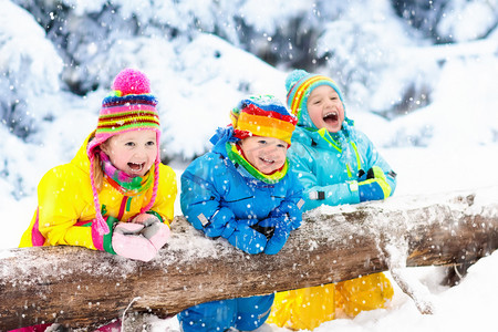 雪地里玩耍摄影照片_孩子们在雪地里玩耍。孩子们在户外玩在冬季降雪.