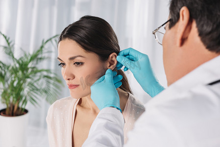 外国医生摄影照片_医生检查女性患者耳的裁剪图像