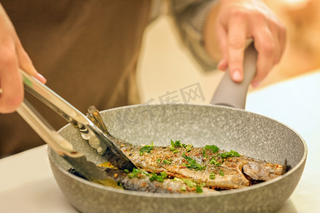 海鲜火锅摄影照片_主厨准备美味鱼在煎锅上