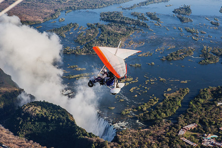 飞花摄影照片_对悬挂式滑翔机在维多利亚瀑布下飞花