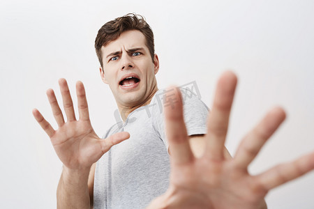 白人男子在他的脸上害怕的表情, 用他的手掌吓坏了手势, 仿佛试图捍卫