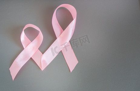 两个粉红丝带提高认识关于乳腺癌，灰色的背景上的图像复制空间