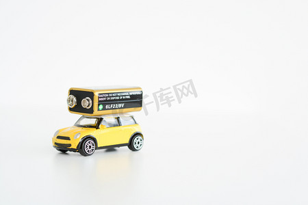 玩具车摄影照片_电动汽车概念与白色背景上的玩具车