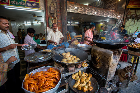 创立体字摄影照片_印度瓦拉纳西-2018年3月25日: 印度街头食品供应商在神圣的恒河边。据传说, 瓦拉纳西是由5000年前的湿婆神创立的。.