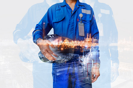 带安全头盔摄影照片_技术员手持带蓝色制服的安全头盔双曝光石油和天然气炼油工业, 工人在石油工业概念