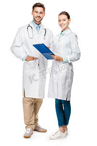 在附近摄影照片_快乐女医生持有剪贴板, 而她的男性同事站在附近的白色隔离 