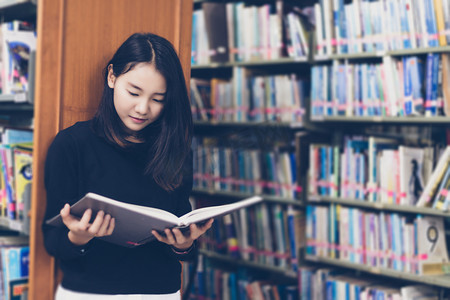 亚洲学生在图书馆看书.