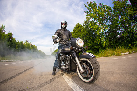 骑自行车的车手留在未知的大斩波车的道路上与轮胎烟雾