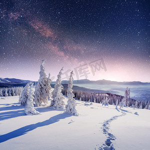 中梦幻摄影照片_在冬雪的夜空中繁星闪烁。梦幻般的银河在除夕夜。冬天路在山里