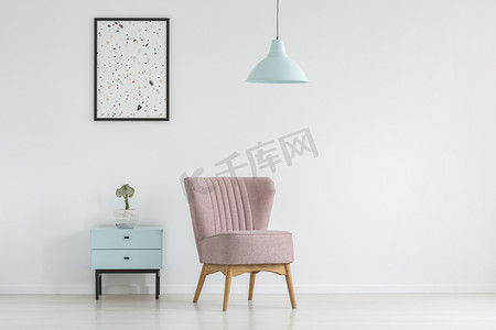 橱柜, 扶手椅, 海报和灯在一个白色的, 空墙在客厅内部。真正的照片。把你的桌子放在这里