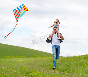 愉快的家庭父亲和孩子女儿奔跑与风筝在草甸