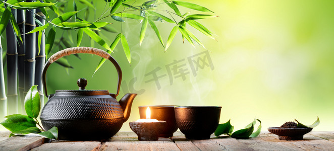 茶壶背景摄影照片_黑铁亚洲茶壶和绿茶叶杯