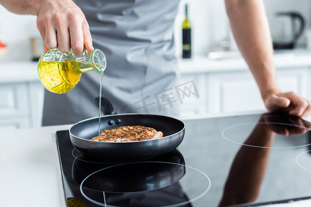 在煎锅里煮牛排时, 围裙上有一张人在停机坪上倒油的镜头