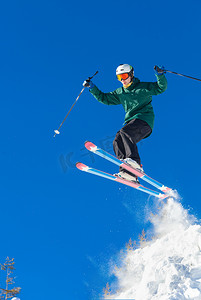 垂直拍摄的专业滑雪运动员跳高在空气中享受滑雪在阳光明媚的美丽的冬季天极端车手自由泳概念. 