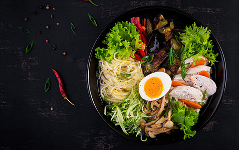 日本拉面汤与鸡，鸡蛋，香菇和茄子在黑暗的木制背景。香子纳贝，相扑汤。顶部视图