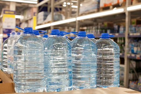超市里装有蓝色瓶盖的塑料瓶,上面有干净的饮用水.用塑料包装包装