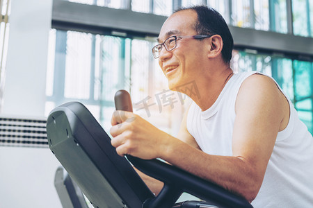 老人在健身中心的跑步机上锻炼。成熟健康的生活方式.