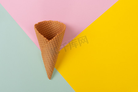 扁平风线摄影照片_冰淇淋蛋筒在柔和五颜六色的背景。最小的夏季概念。扁平.