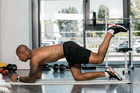 在健身房健身垫运动的肌肉非洲裔美国人的侧面视图