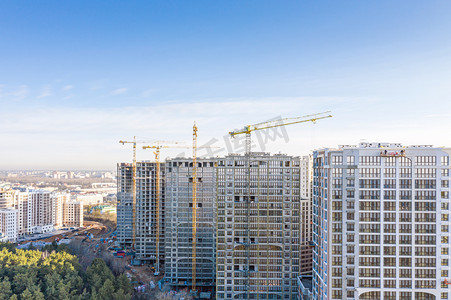 正在进行中的大型土木建筑工地的全景航拍，黄鹤在蓝天的映衬下