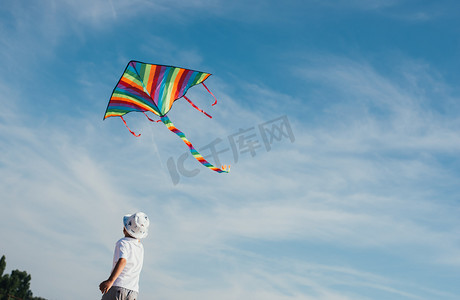 古风女风筝摄影照片_可爱的孩子玩彩色风筝的低角度视图