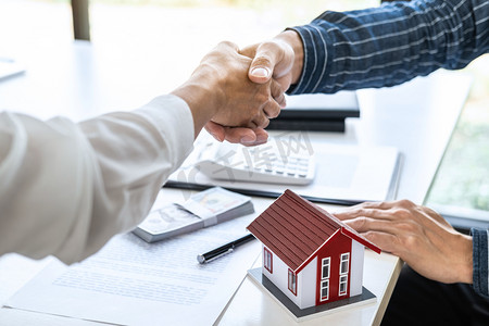 地产代理与客户在签订了房屋保险、投资贷款、握手及成功交易等协议后，携手庆祝合约的签订.