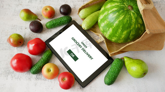 棉包摄影照片_棉包和平板电脑中的有机蔬菜和水果、在线市场、家庭绿色食品递送概念、特写镜头