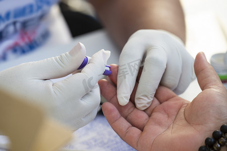 期间摄影照片_巴西里约热内卢-2018年11月22日: 医疗保健专业人员在筛查活动期间快速血糖检测
