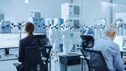 在清洁工场：穿着工作服和面具的专业工作者使用笔记本电脑和说话。厂内办公室：女性电子工程师从事计算机、屏幕显示电路板3D设计