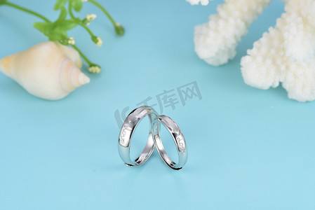 白色钻石花朵摄影照片_白色背景的结婚戒指和耳环