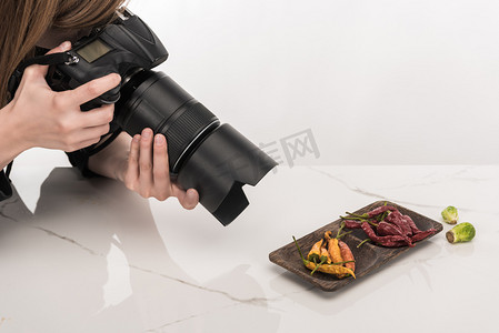 摄影师剪影摄影照片_女性摄影师为商业摄影制作食物，并在白色数码相机上拍照的剪影