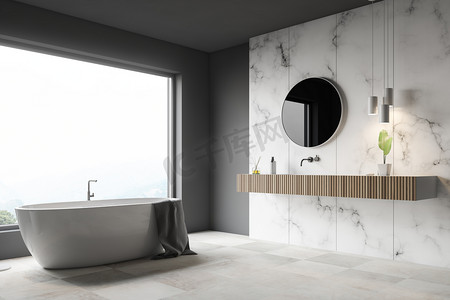 豪华圆形摄影照片_豪华浴室的角落, 有灰色和白色的大理石墙壁, 大窗户, 白色瓷砖地板, 白色浴缸和木水槽与圆形镜子。3d 渲染