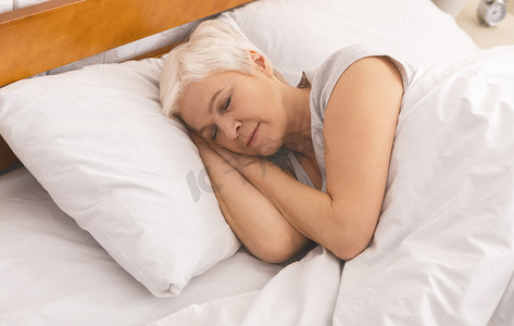senior摄影照片_Senior lady sleeping in bed in morning, panorama