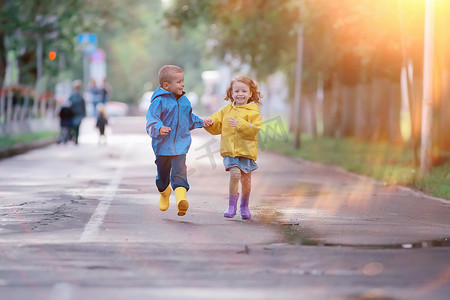 秋天孩子们在黄秋公园里跑雨/好玩地走秋季时景天气湿润