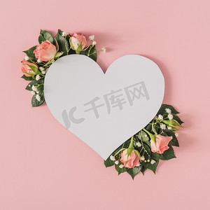 绿色背景海报创意摄影照片_Heart shape paper card note with natural spring wild flowers, Women day and spring season minimal concept