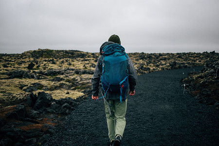 诺威摄影照片_年轻人在崎岖的冰岛地形中徒步