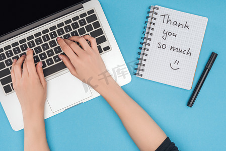 裁剪视图的妇女在计算机和笔记本上工作, 感谢你这么多的字母孤立在蓝色背景