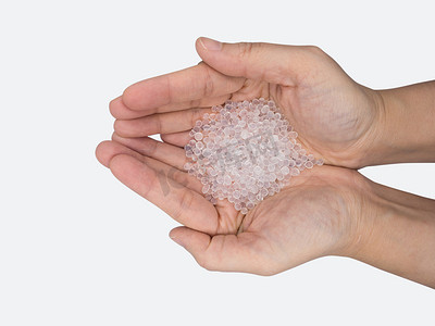 agent摄影照片_Close up of hand holding silica gel on white background, Desiccant attract moisture for chemical.