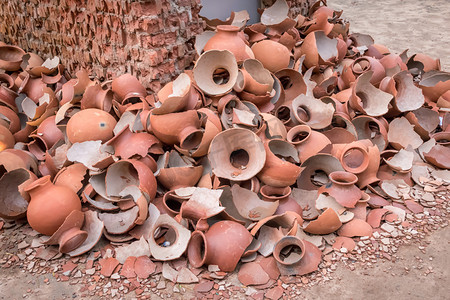 废弃棚屋上堆放破碎黏土陶器或陶器或传统罐子的图片.