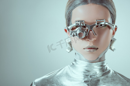 漂亮机器人摄影照片_银机器人近距离观察相机隔离在灰色, 未来的技术概念 