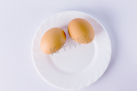 白盘上的两个煮熟的鸡蛋.