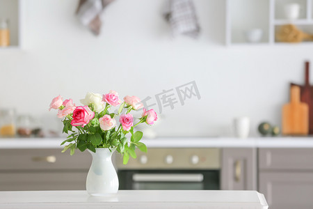 roses摄影照片_Beautiful rose flowers in vase on table in kitchen