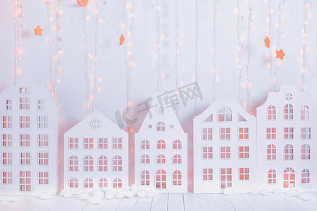 童话般的圣诞内饰, 有白色的多层房屋和花环。新年装饰。假日卡。圣诞节背景. 
