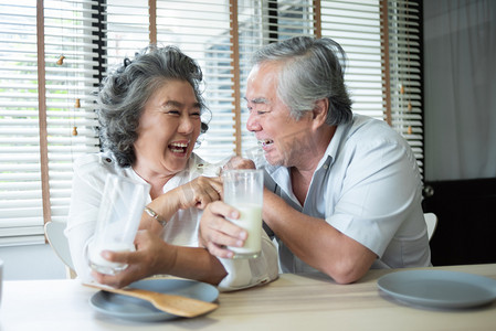 热爱喝牛奶的亚洲老年夫妇.