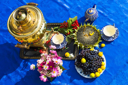 夏末摄影照片_夏末。萨莫瓦尔, 一杯茶, 鲜花和礼物